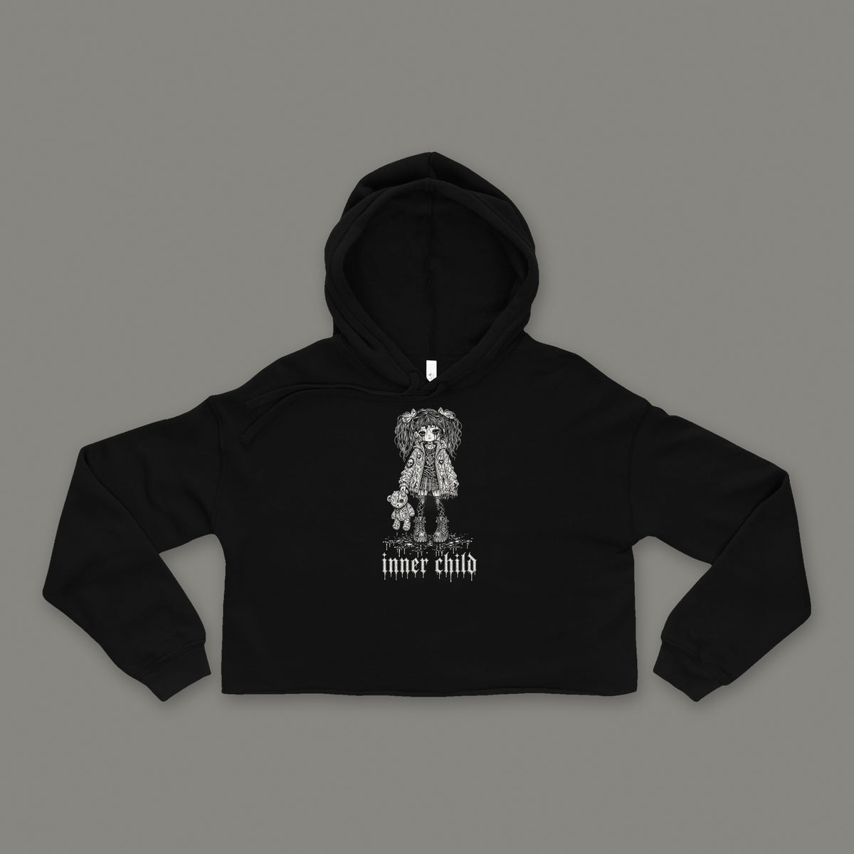 Inner Child Cropped Hoodie by Trauma Dump, black goth cropped hoodie front with girl and teddy bear print, mockup view 2