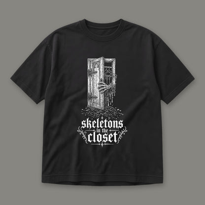 Skeletons in the Closet Men's Heavyweight Tee in black by Trauma Dump, skeleton hand in a closet door tattoo-style gothic graphic in white ink (Black, white ink)