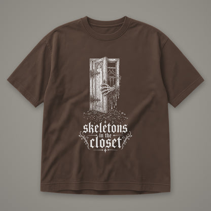 Skeletons in the Closet Men's Heavyweight Tee in espresso by Trauma Dump, skeleton hand in a closet door tattoo-style gothic graphic in white ink (Espresso, white ink)
