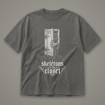 Skeletons in the Closet Men's Heavyweight Tee in pepper by Trauma Dump, skeleton hand in a closet door tattoo-style gothic graphic in white ink (Pepper, white ink)