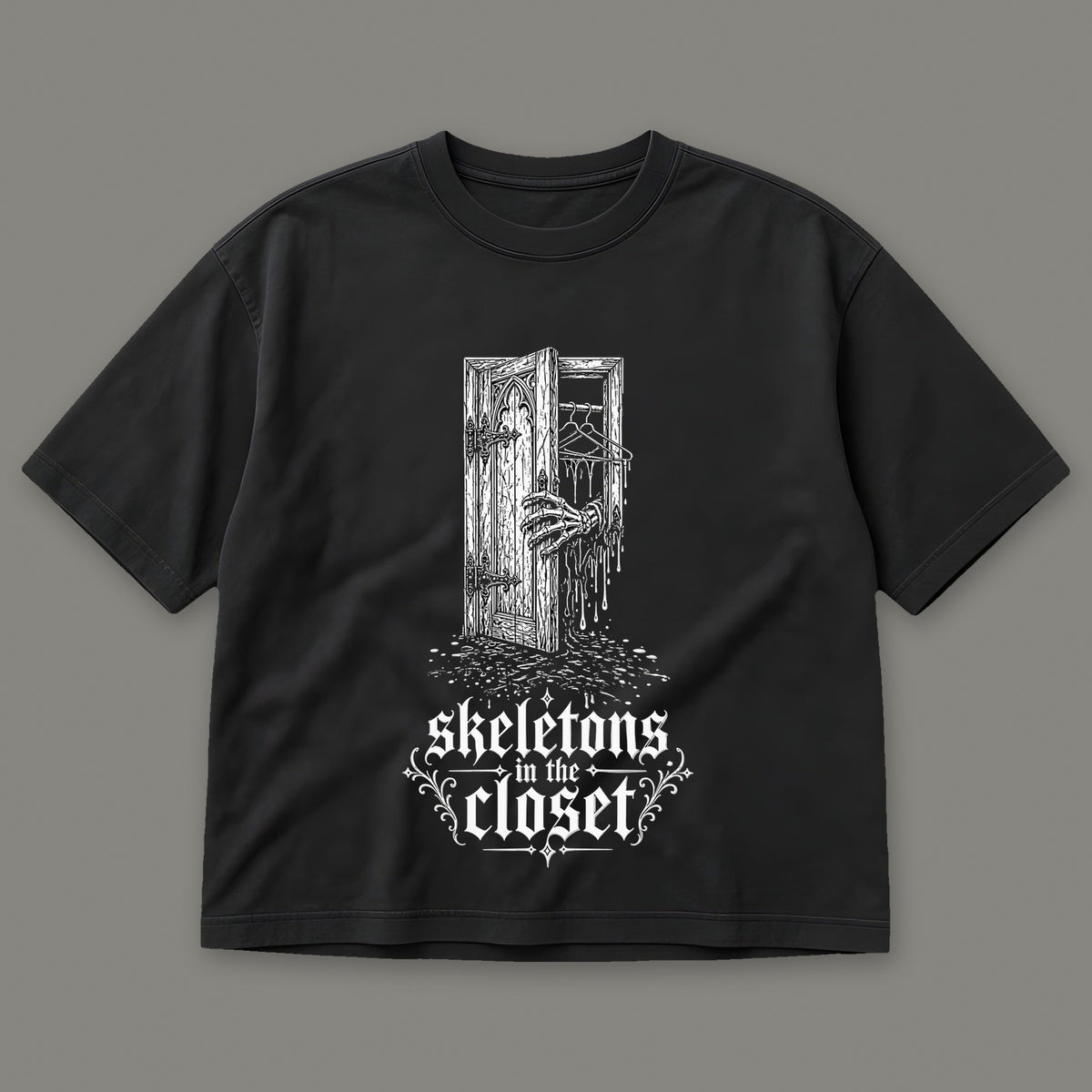 Skeletons in the Closet Women's Boxy Tee in black by Trauma Dump, skeleton hand in a closet door tattoo-style gothic graphic (Black, white ink)
