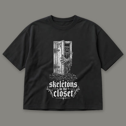 Skeletons in the Closet Women's Boxy Tee in black by Trauma Dump, skeleton hand in a closet door tattoo-style gothic graphic (Black, white ink)