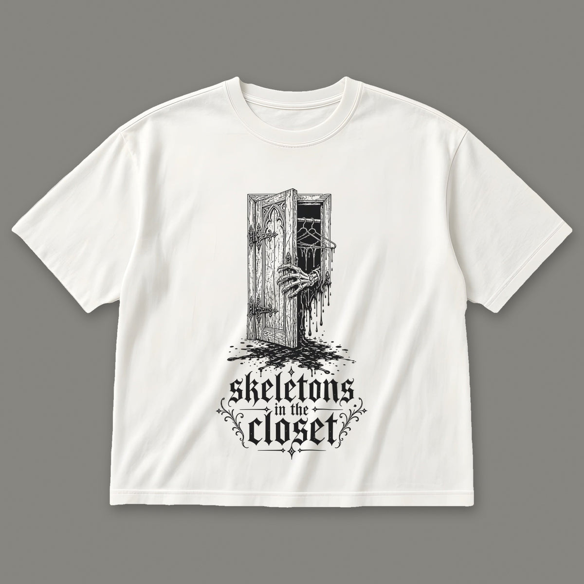 Skeletons in the Closet Women's Boxy Tee in white by Trauma Dump, skeleton hand in a closet door tattoo-style gothic graphic in black ink