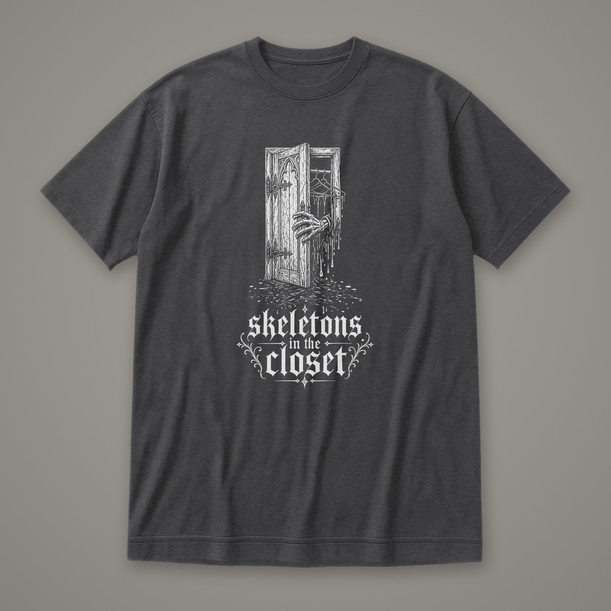 Skeletons in the Closet Women's Relaxed Tee in dark grey heather by Trauma Dump, skeleton hand in a closet door tattoo-style gothic graphic in white ink (Dark Grey Heather, white ink)
