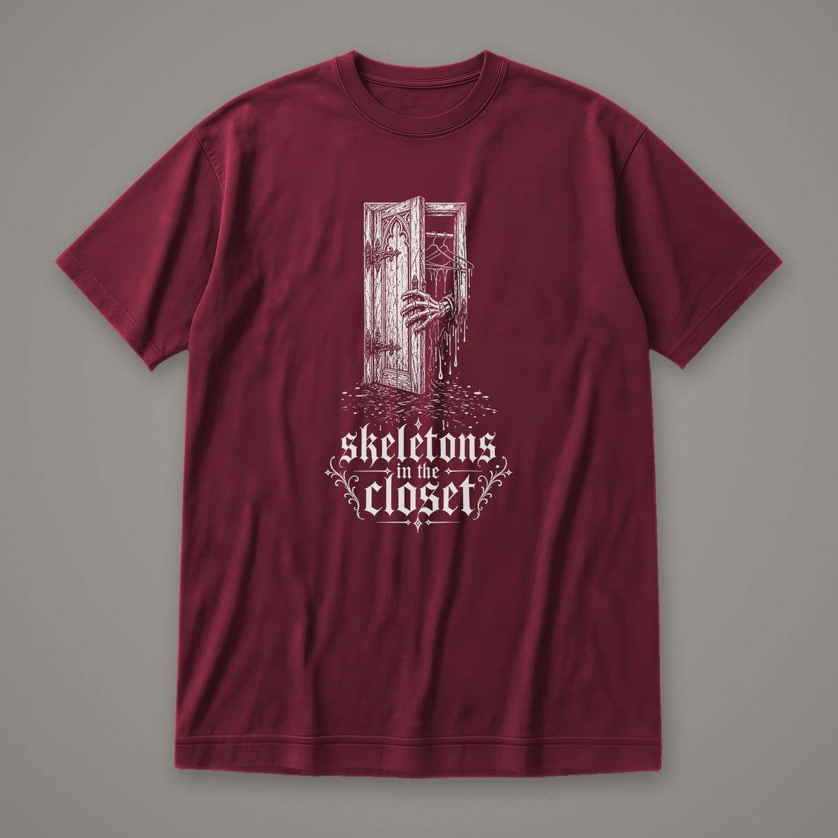 Skeletons in the Closet Women's Relaxed Tee in maroon by Trauma Dump, skeleton hand in a closet door tattoo-style gothic graphic in white ink (Maroon, white ink)