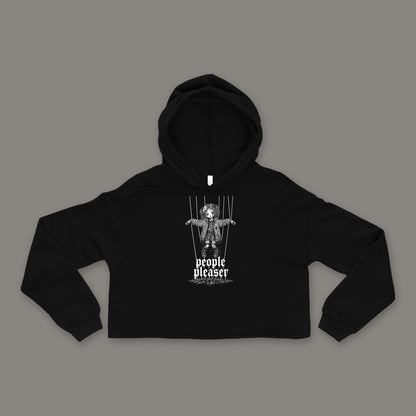 People Pleaser Cropped Hoodie by Trauma Dump, black goth cropped hoodie front with cut-strings marionette print, mockup view 3 (Black, white ink)